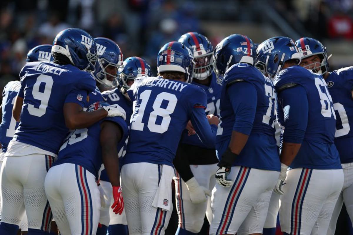 : J.J. McCarthy #18 of the New York Giants calls a team huddle