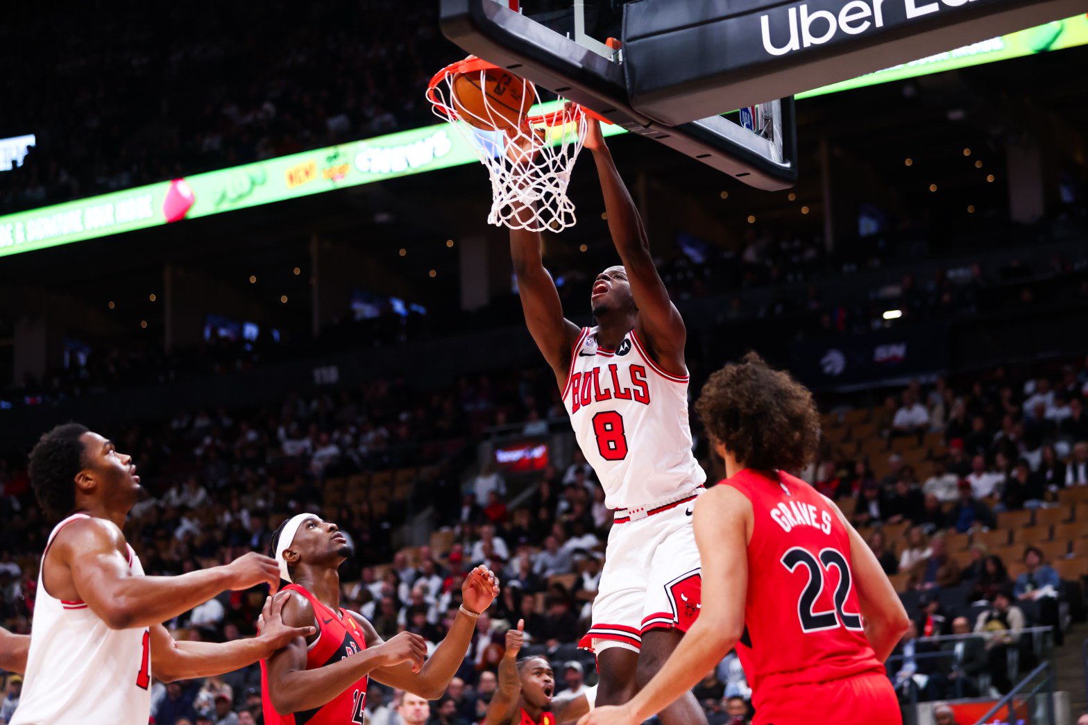 Caleb Wilson of the Chicago Bulls dunks against Allen Graves and Ja'Kobe Walter of the Toronto Raptors in the second half at Scotiabank Arena on Oct. 21, 2026, in Toronto, Canada (Cole Burston/Getty Images)