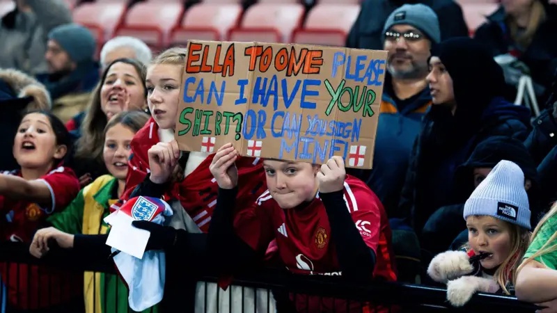 Young Man Utd fans hold Ella Toone banner 