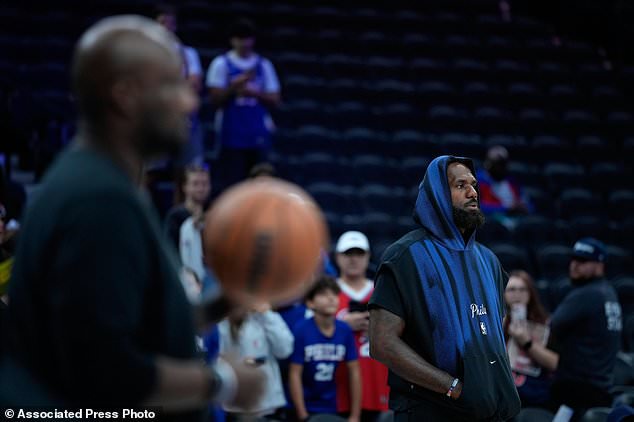 Philadelphia 76ers' LeBron James watches warm-ups before a preseason NBA basketball game against the Boston Celtics Friday, Oct. 16, 2026, in Philadelphia. (AP Photo/Matt Slocum)