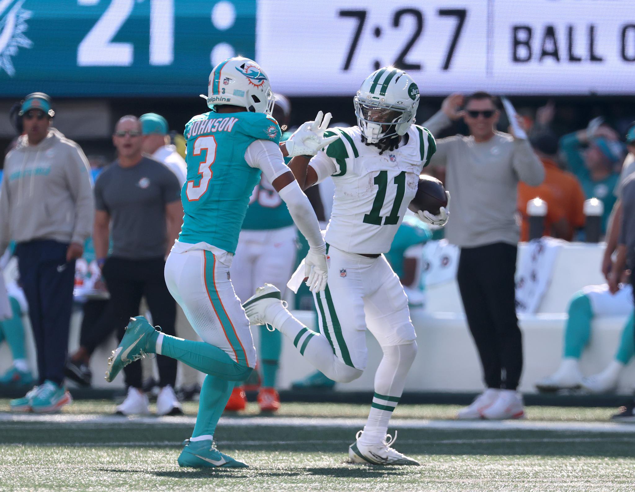 New York Jets player running with the football against the Miami Dolphins.