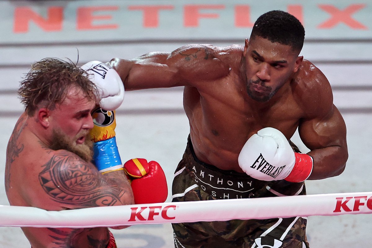 Anthony Joshua landing a punch on Jake Paul during a boxing match