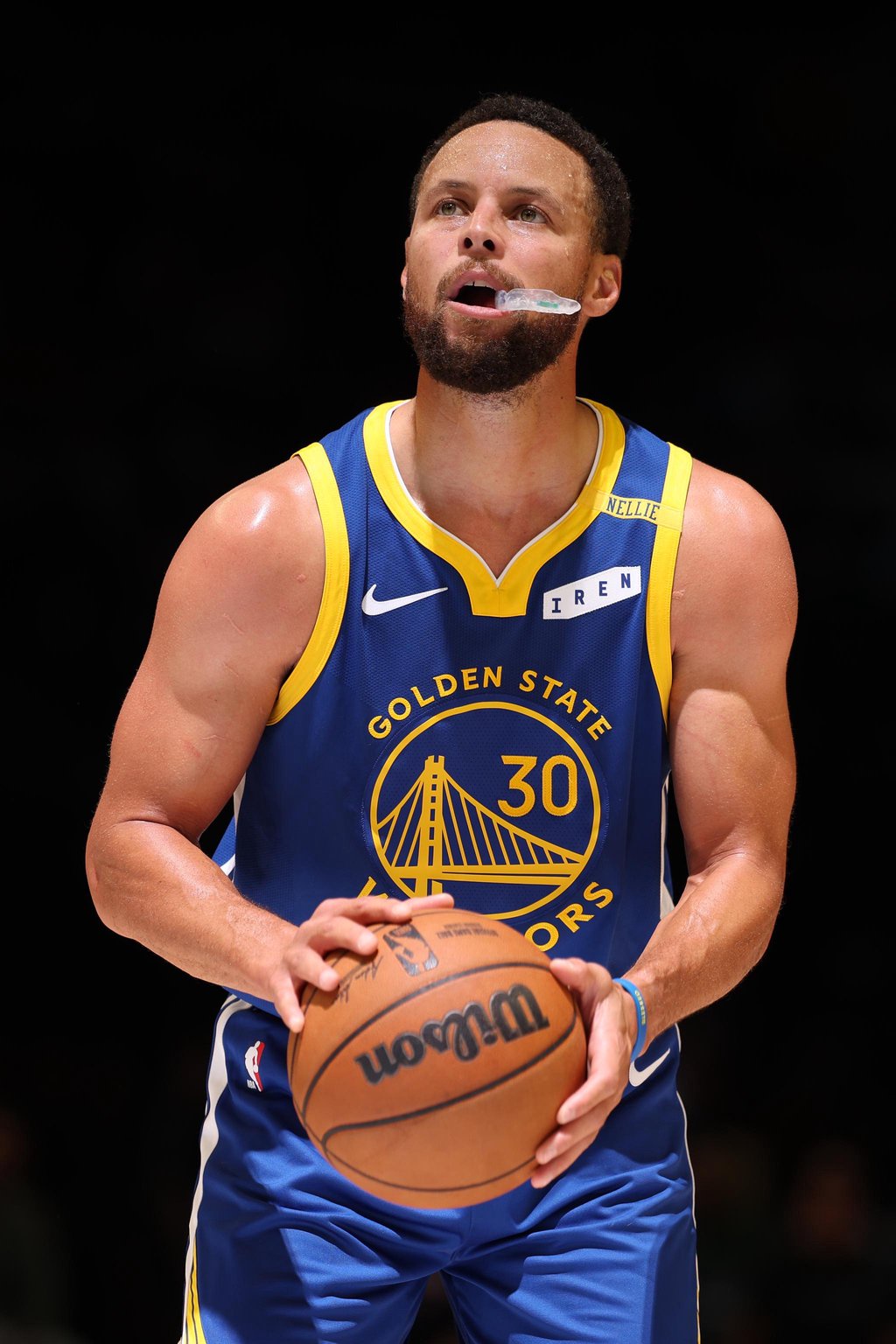 Stephen Curry of the Golden State Warriors prepares to shoot a free throw with a mouthguard in his mouth.