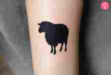 A black sheep silhouette tattoo on the forearm