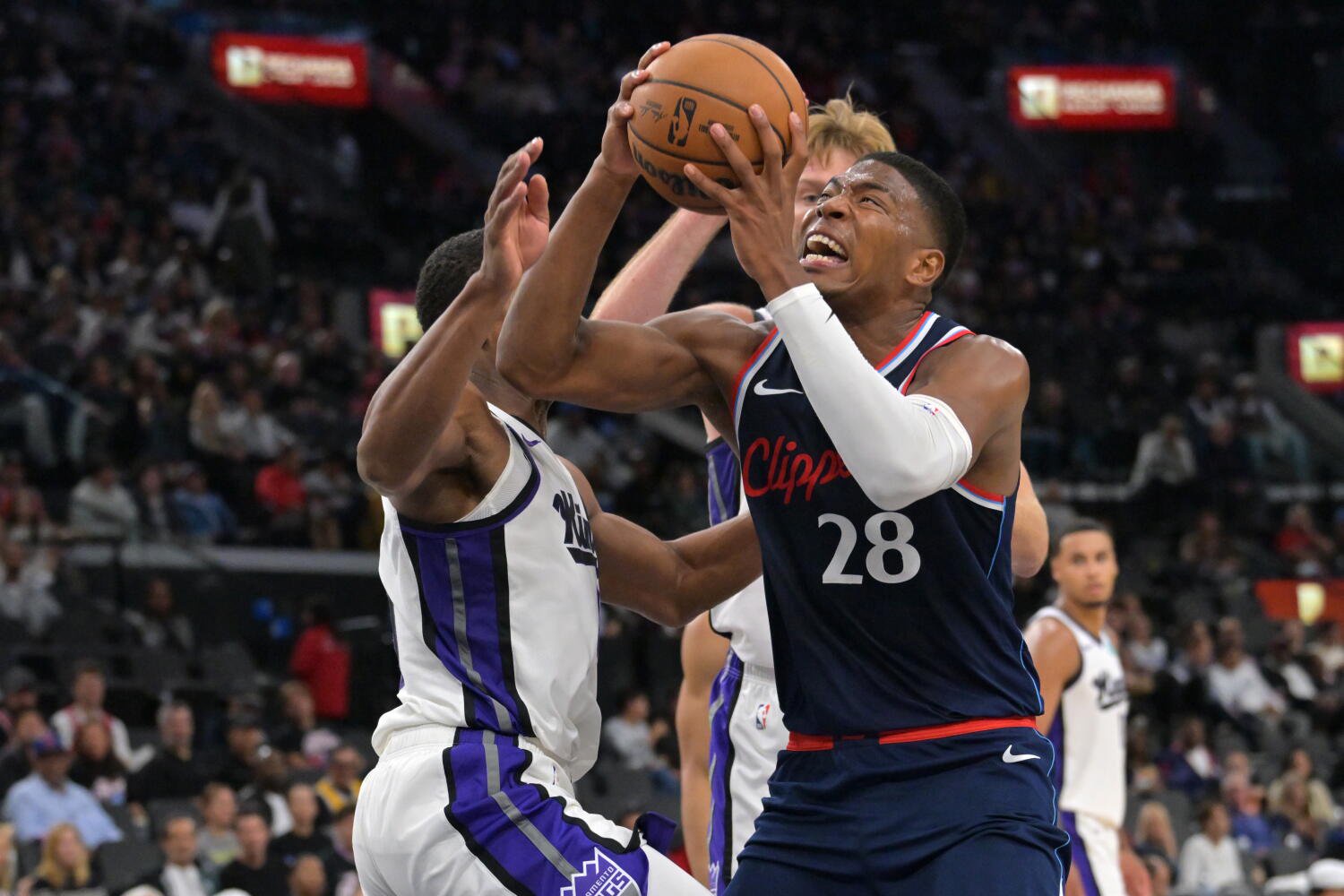 Clippers forward Rui Hachimura drives past Kings guard De'andre Hunter and center Domantas Sabonis Wednesday.