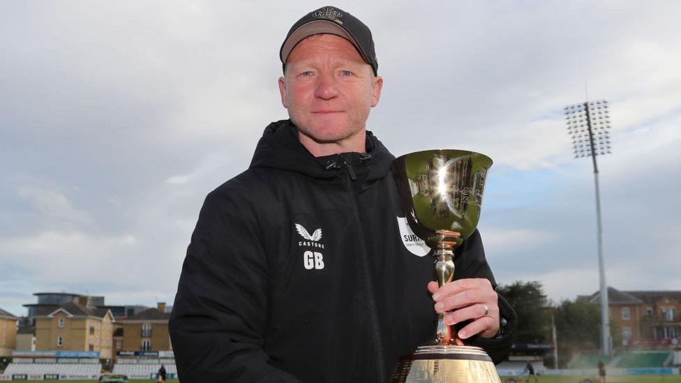 Gareth Batty in Surrey hoodie holding the County Championship trophy