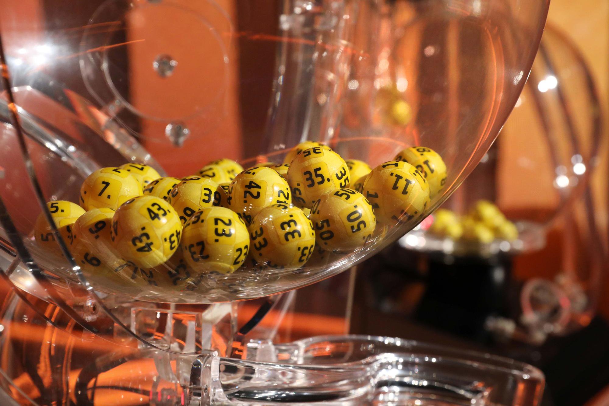 Lotto-Ziehungsmaschine mit gelben Kugeln im Fernsehstudio.