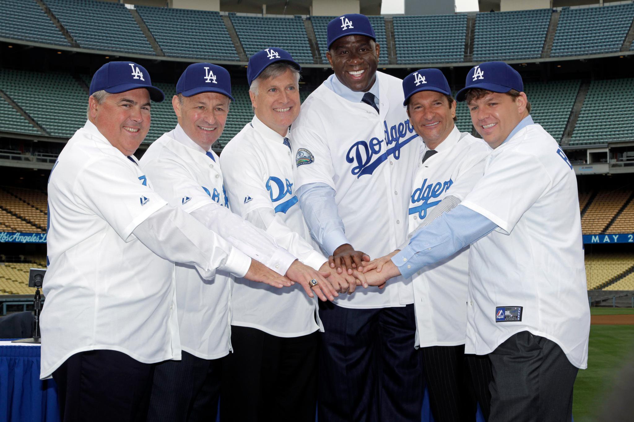 New owners of the Los Angeles Dodgers, from left, Robert Patton, Stan Kasten, Mark Walter, Earvin "Magic" Johnson, Peter Guber and Todd Boehly pose for a photo at Dodger Stadium.