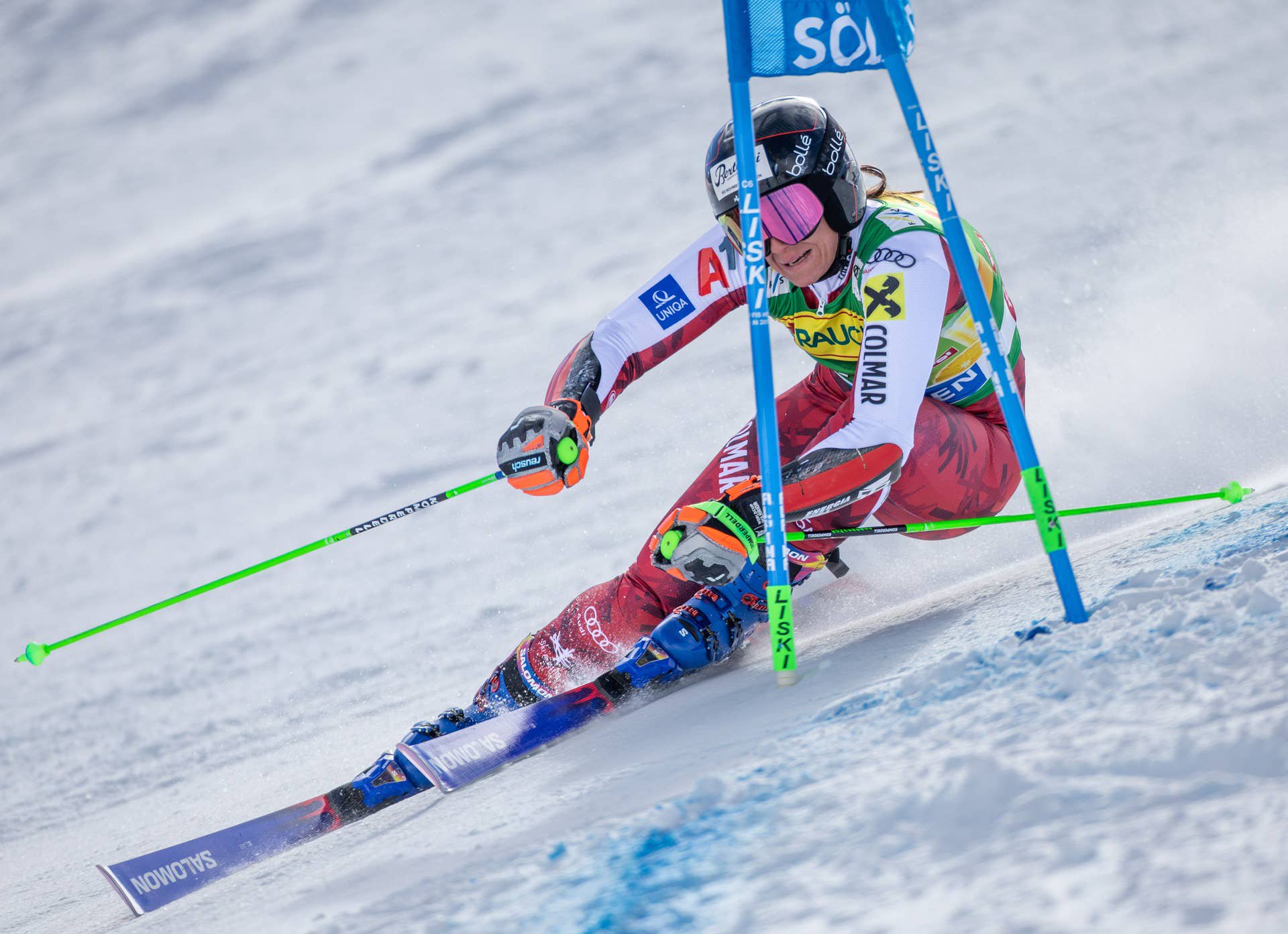 Eine Skirennläuferin fährt beim Riesenslalom um ein blaues Tor im Schnee.