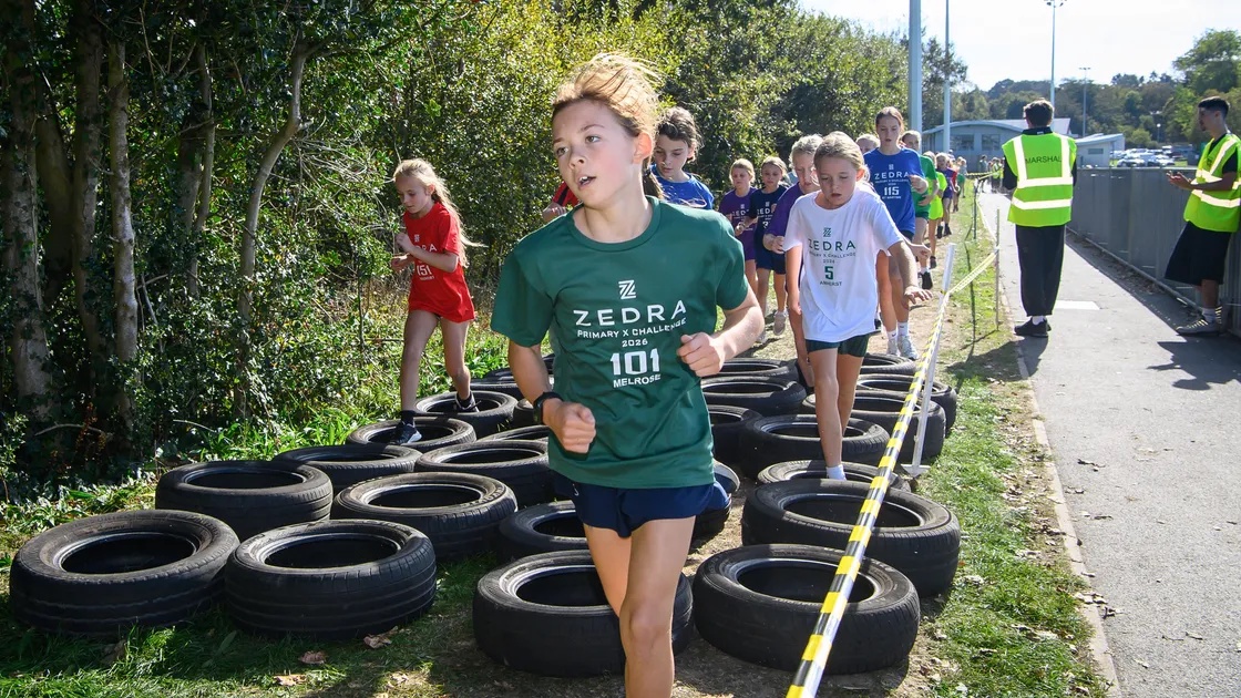 Competitors scramble over tyres in the primary girls’ race.