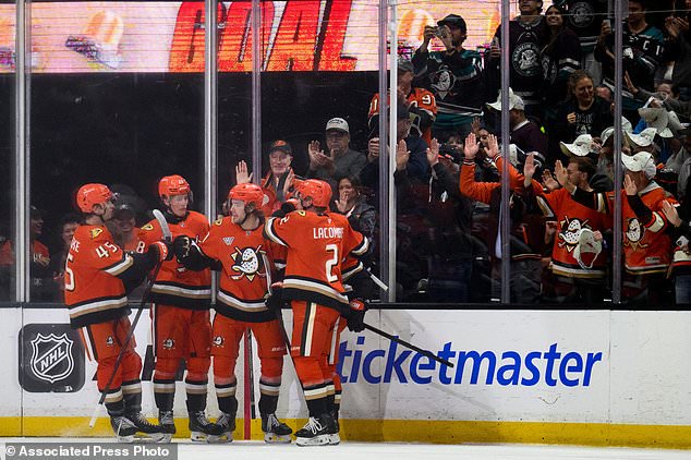 Anaheim Ducks players celebrate a goal by center Leo Carlsson (91) during the first period of an NHL hockey game against the Calgary Flames, Tuesday, Oct. 13, 2026, in Anaheim, Calif. (AP Photo/Kyusung Gong)