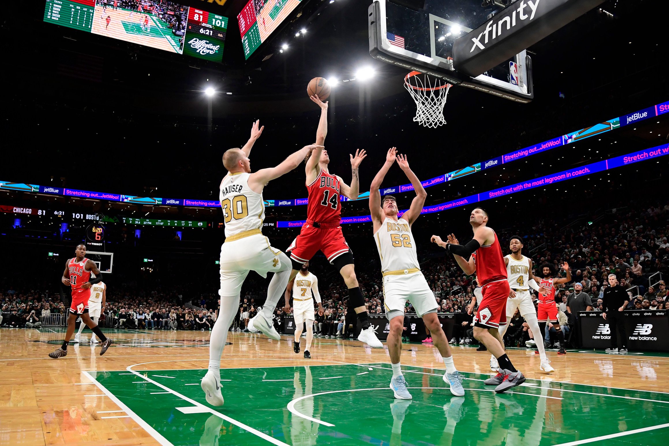 Jan 5, 2026; Boston, Massachusetts, USA; Chicago Bulls forward Matas Buzelis (14) shoots the ball while Boston Celtics forward Sam Hauser (30) and center Luka Garza (52) defend during the second half at TD Garden. Mandatory Credit: Bob DeChiara-Imagn Images
