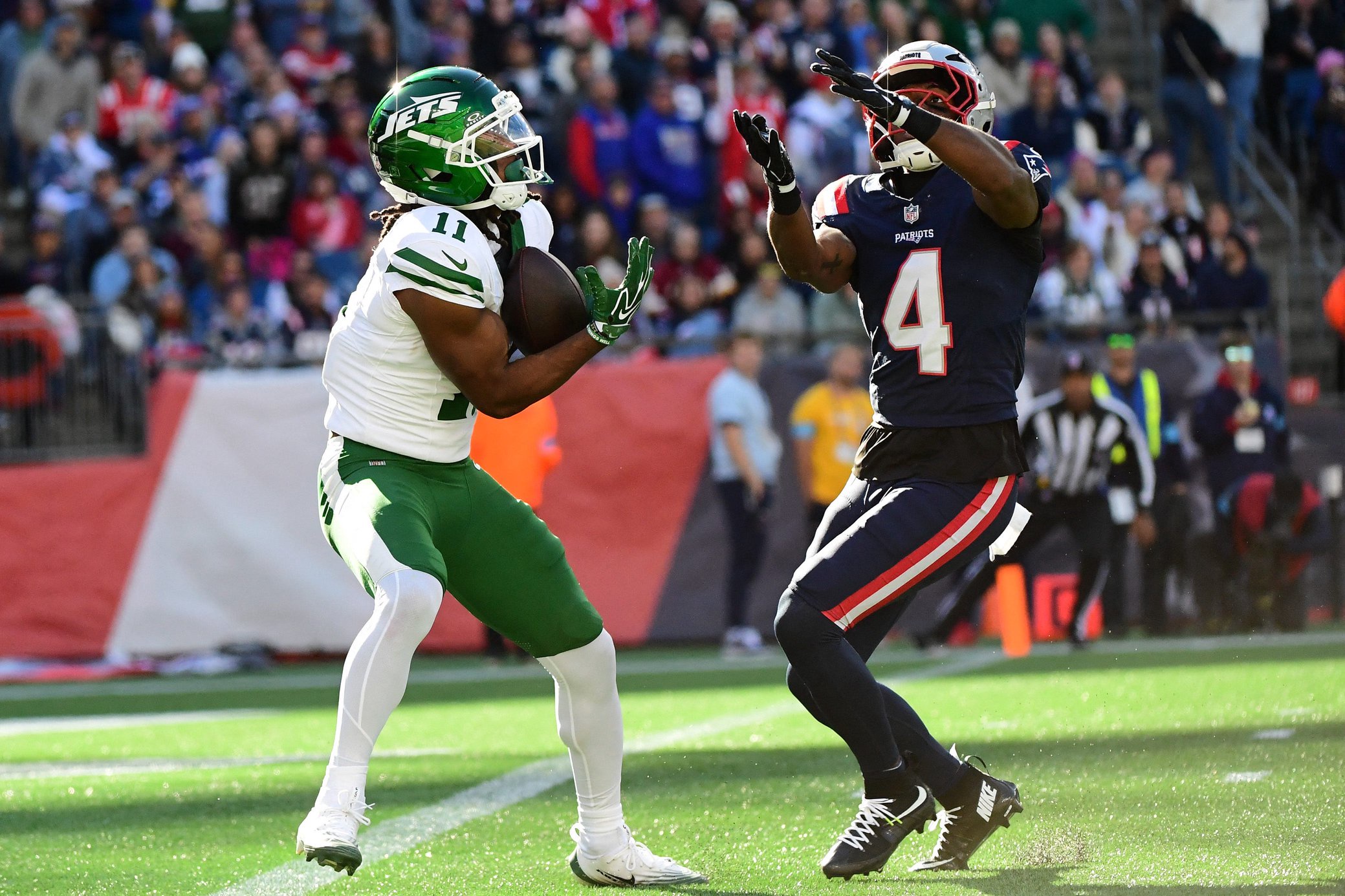 Oct 18, 2026; Foxborough, Massachusetts, USA;  New York Jets wide receiver Omar Cooper Jr. (11) catches the ball past New England Patriots safety Craig Woodson (4) for a touchdown during the second half at Gillette Stadium. Mandatory Credit: Bob DeChiara-Imagn Images