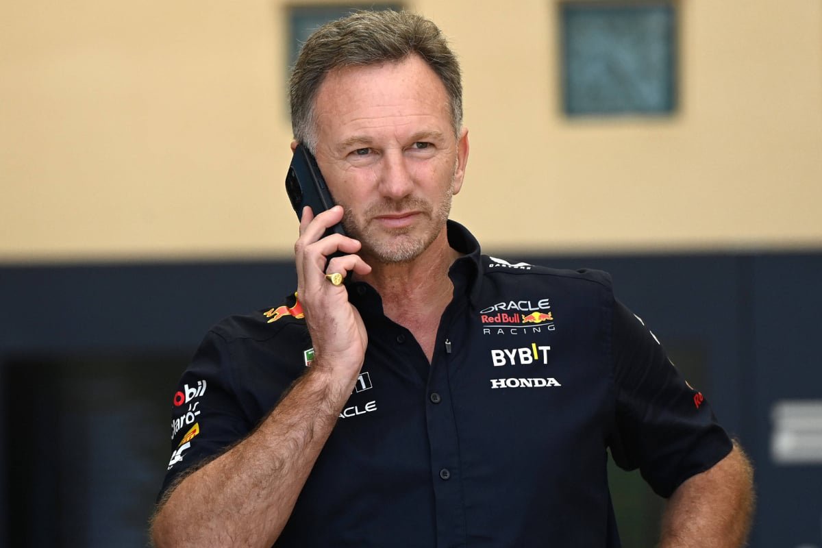 Horner in Red Bull kit looking down at his phone — Photo: © IMAGO