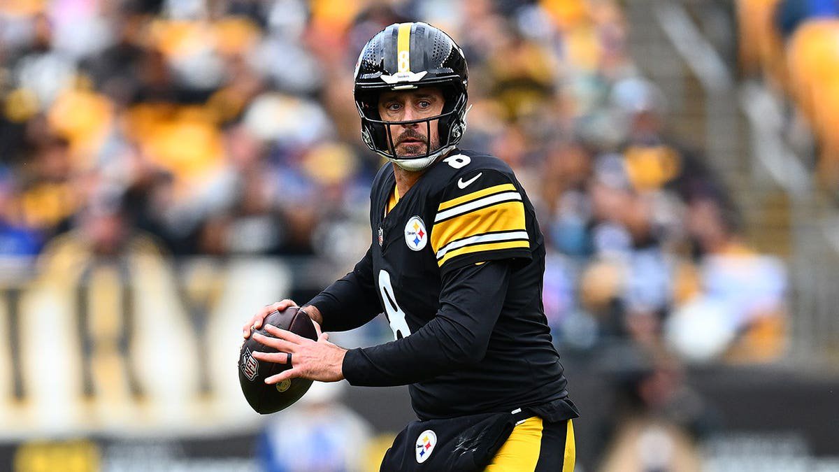 Aaron Rodgers looks to pass during a game at Acrisure Stadium.