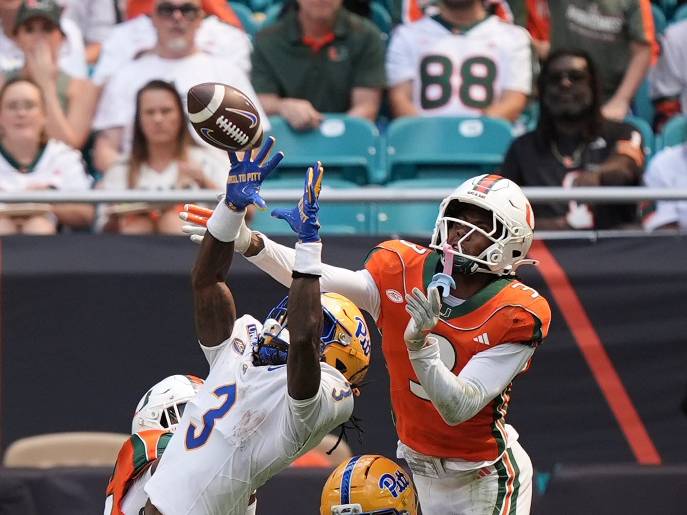 Pittsburgh wide receiver Cataurus Hicks, left, makes a catch under pressure from Miami defensive back Bryce Fitzgerald, right, during the first half of an NCAA college football game, Saturday, Oct. 24, 2026, in Miami Gardens, Fla. (AP Photo/Rebecca Blackwell)