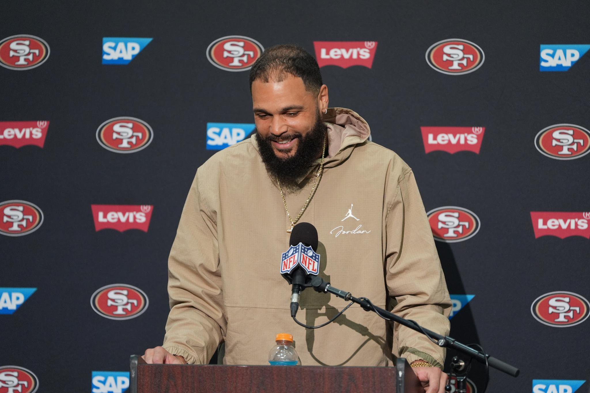 San Francisco 49ers wide receiver Mike Evans talks to reporters at a podium.