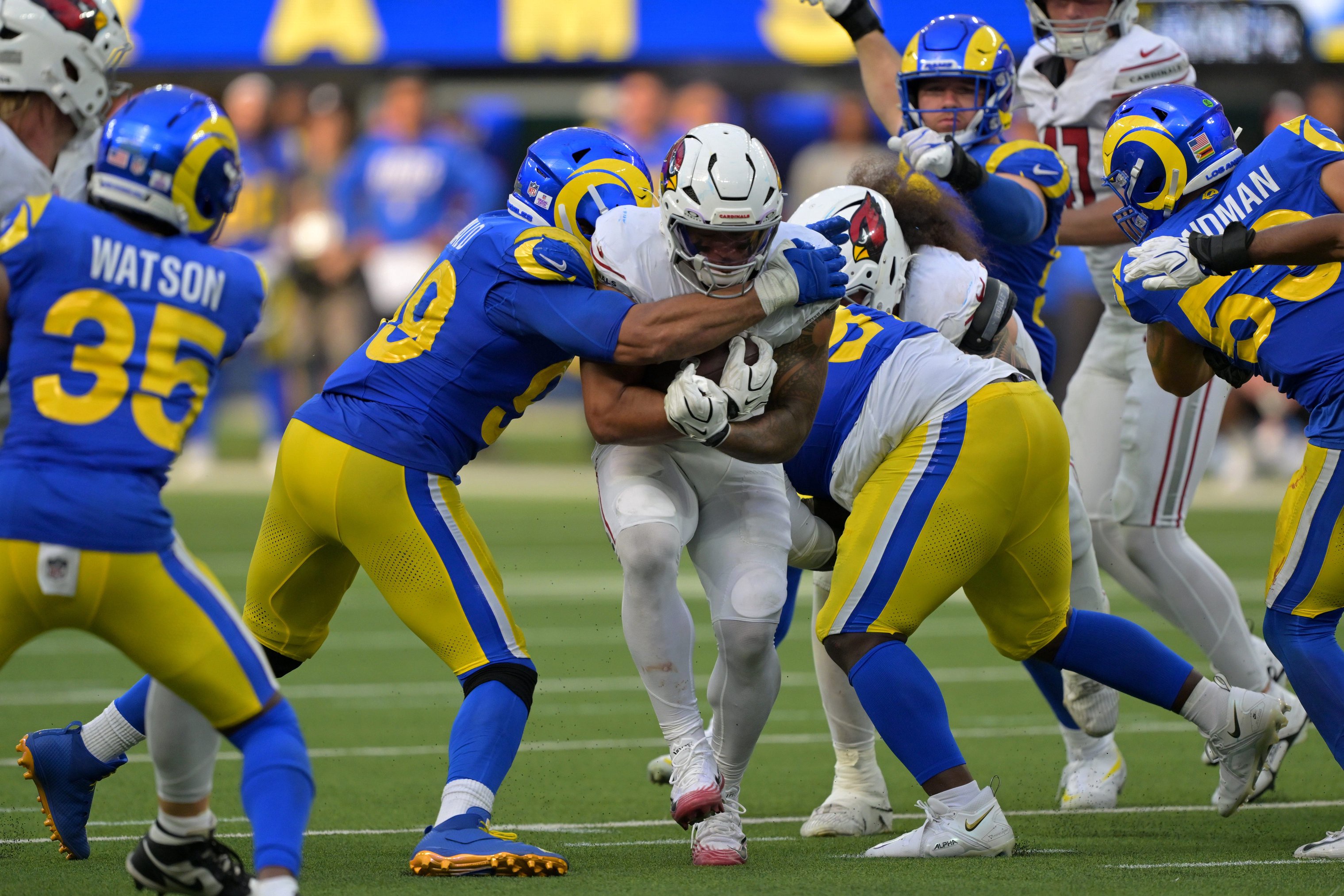 Oct 18, 2026; Inglewood, California, USA;  Arizona Cardinals running back Tyler Allgeier (22) is stopped by Los Angeles Rams defensive tackle Aaron Donald (99) and nose tackle Poona Ford (97) in the fourth quarter at SoFi Stadium.  Mandatory Credit: Jayne Kamin-Oncea-Imagn Images