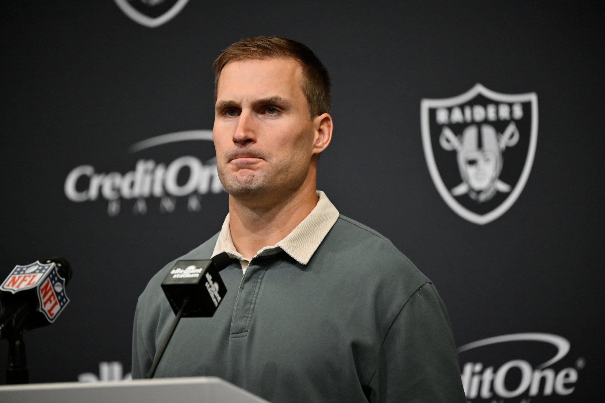 Kirk Cousins at a podium during a press conference.