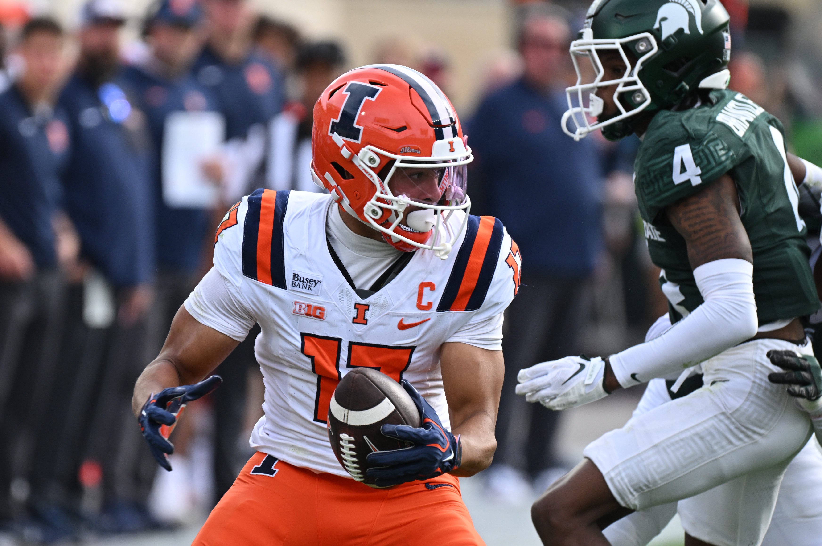 Oct 10, 2026; East Lansing, Michigan, USA;  Illinois Fighting Illini wide receiver Collin Dixon (17) tries to evade Michigan State Spartans defensive back Charles Brantley (4) during the first quarter at Spartan Stadium.  Mandatory Credit: Dale Young-Imagn Images
