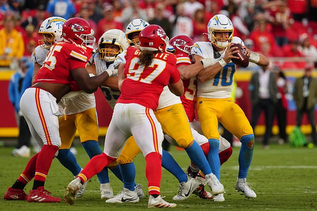Los Angeles Chargers quarterback Justin Herbert (10) is sacked by Kansas City Chiefs defensive end George Karlaftis, second from right, during the second half of an NFL football game in Kansas City, Mo., Sunday, Oct. 18, 2026. (AP Photo/Ed Zurga)