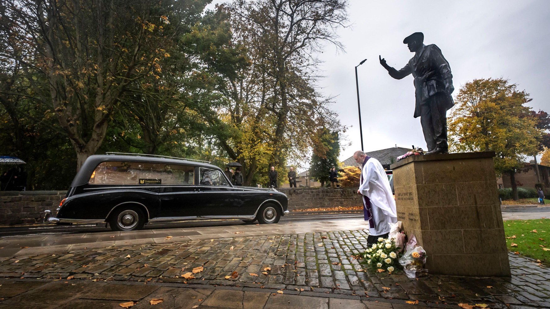 The funeral cortege for Dickie Bird passes the life-size bronze statue of Dickie Bird near St Mary’s Church, Barnsley.