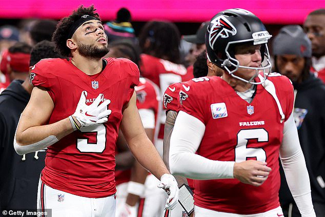 Drake London #5 and Nick Folk #6 of the Atlanta Falcons react after teammate Daniels' injury