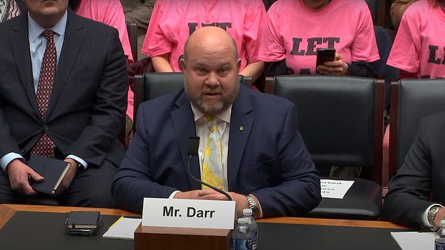 The group of female protesters stragegically sat behind the witnesses to appear on the hearing's livestream