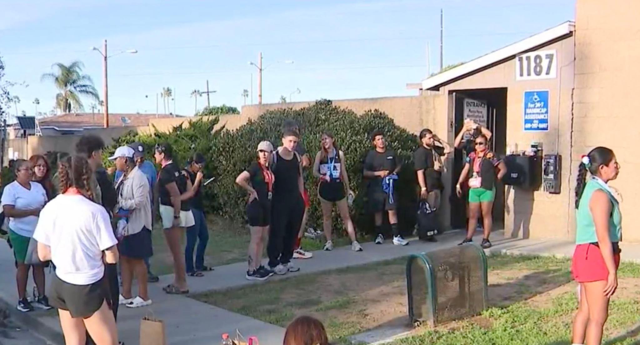 A group of runners waiting outside a building during the Binational Half Marathon.