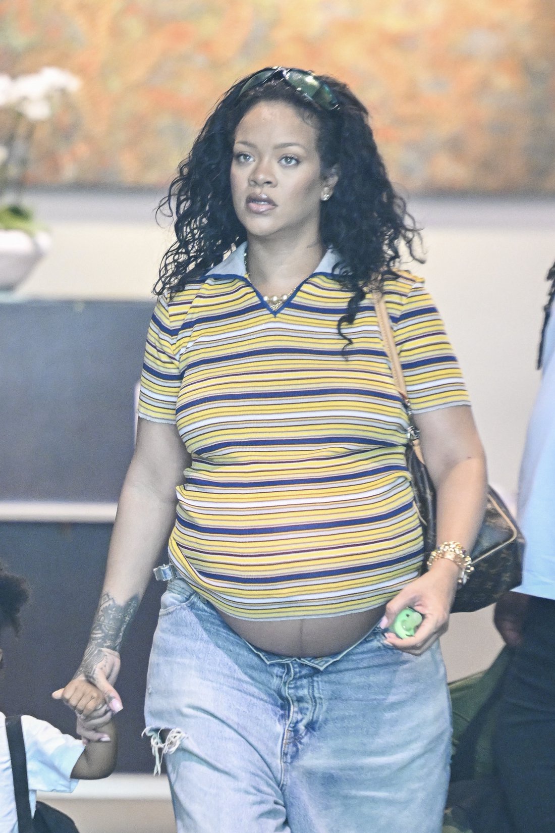 Rihanna in Los Angeles showing her baby bump while holding her son's hand.