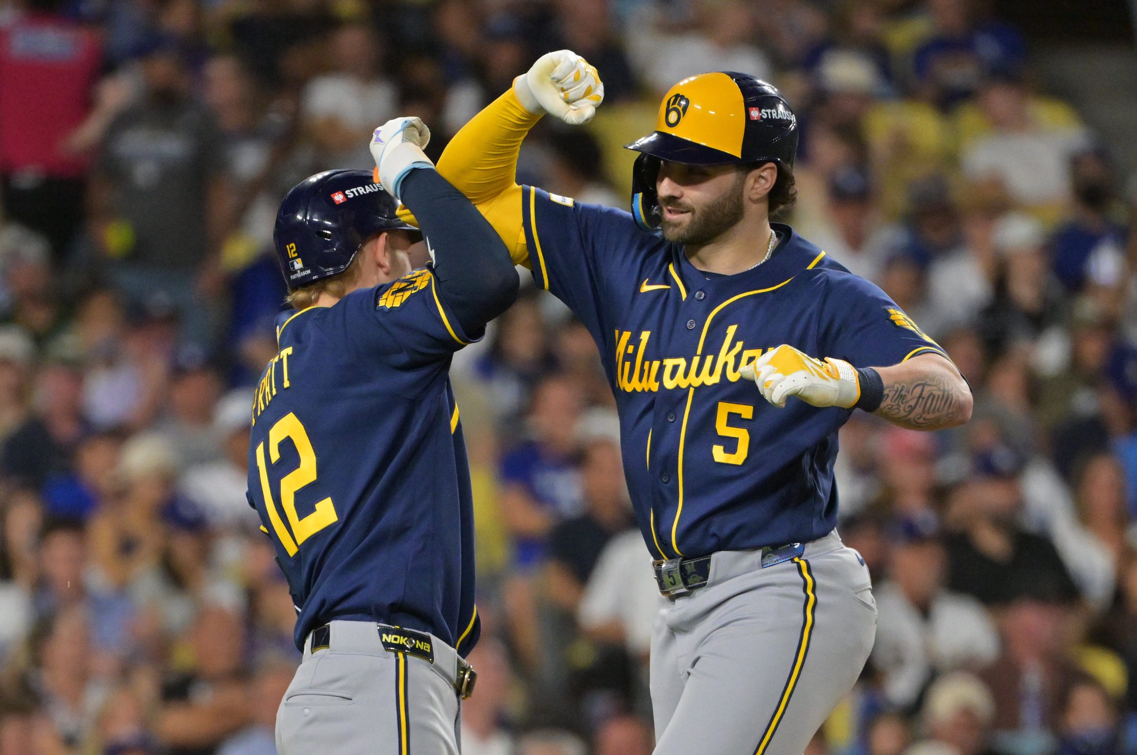 Milwaukee Brewers outfielder Garrett Mitchell (5) celebrates with shortstop Cooper Pratt (12) after a home run against the Los Angeles Dodgers during the sixth inning of Game 4. 