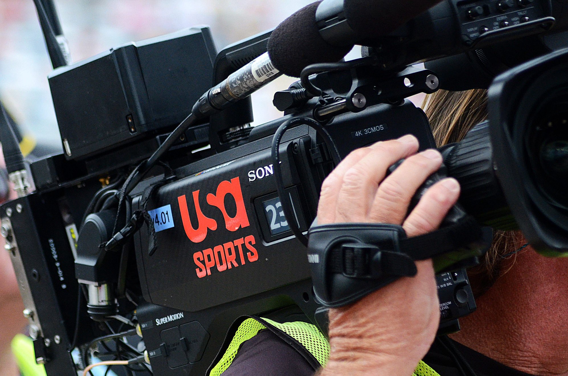 A cameraman holds a USA Sports-branded camera on pit road ahead of the Bank of America 400 at Charlotte Motor Speedway on Sunday, Oct. 11, 2026.