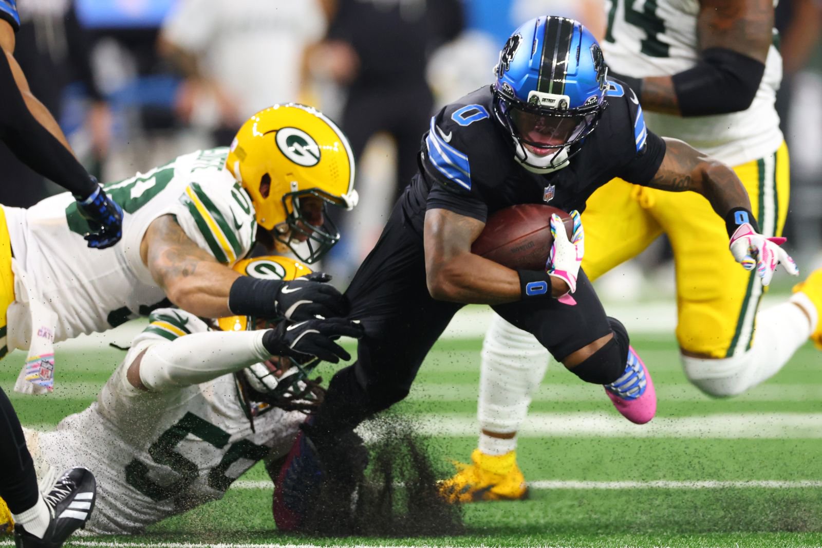 Jahmyr Gibbs #0 of the Detroit Lions is tackled by Ty'ron Hopper #59 of the Green Bay Packers