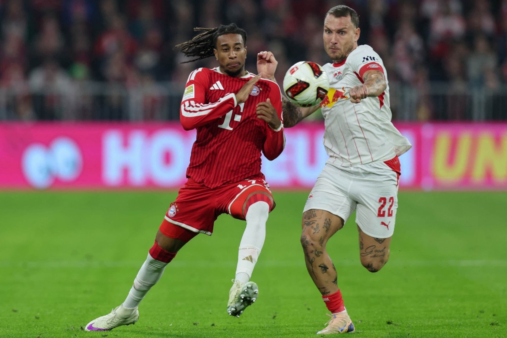 Bayerns Michael Olise (l.) gegen Leipzigs David Raum