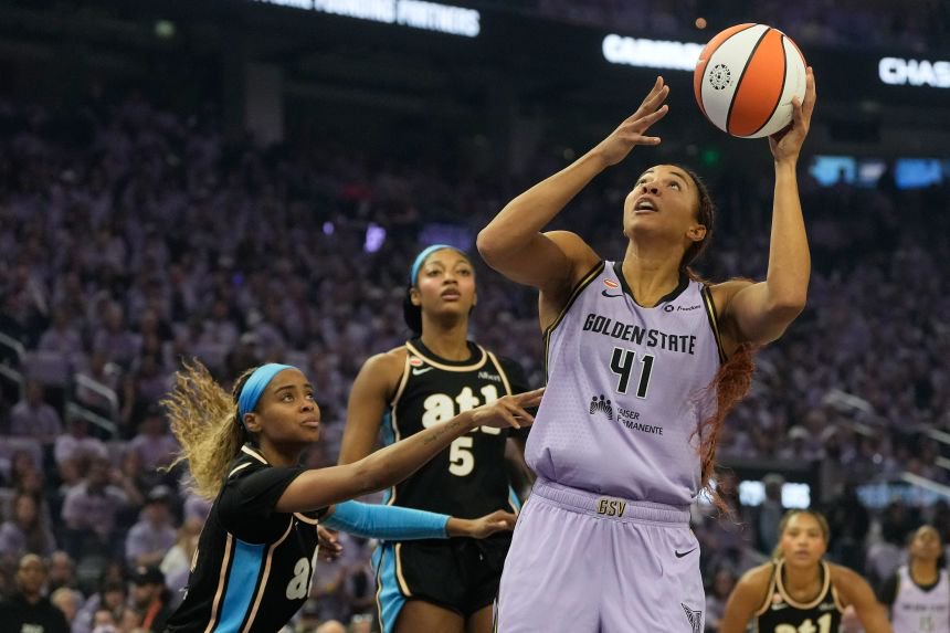 Golden State Valkyries center Kiah Stokes shoots against Atlanta Dream guard Jordin Canada, left, and forward Angel Reese (5).