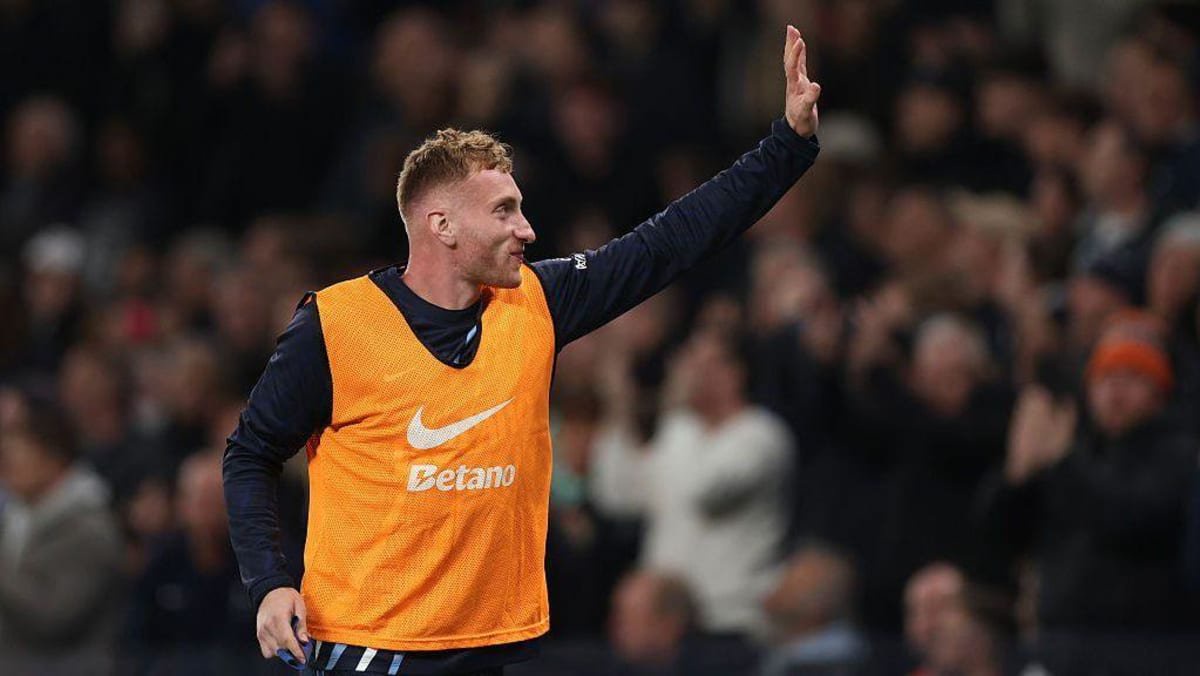 Dejan Kulusevski waves to the Spurs fans while warming up