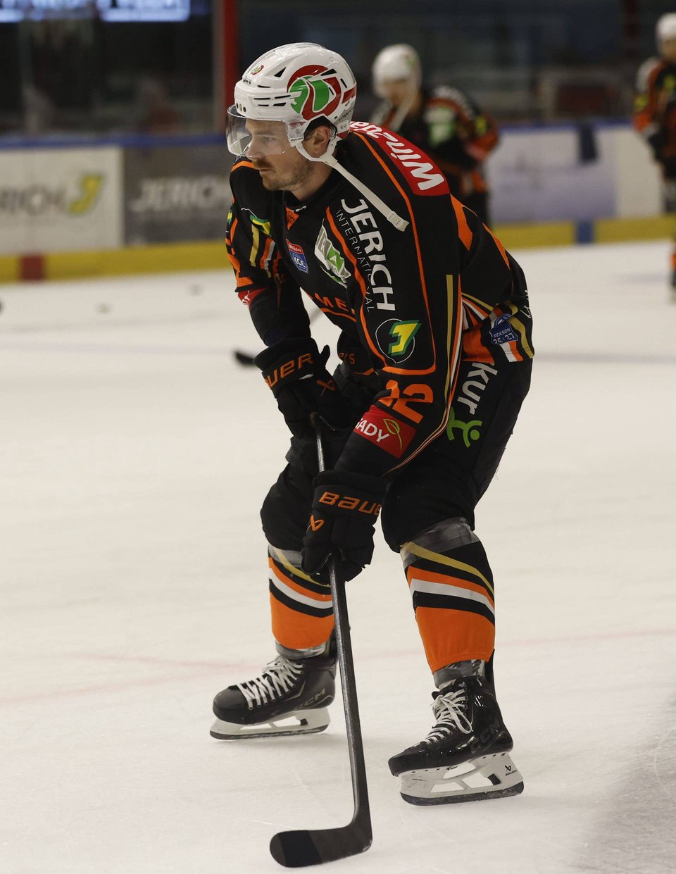 Eishockey-Spieler Kevin Conley von den Graz99ers steht im dunklen Trikot fokussiert auf dem Eis und hält den Schläger spielbereit.