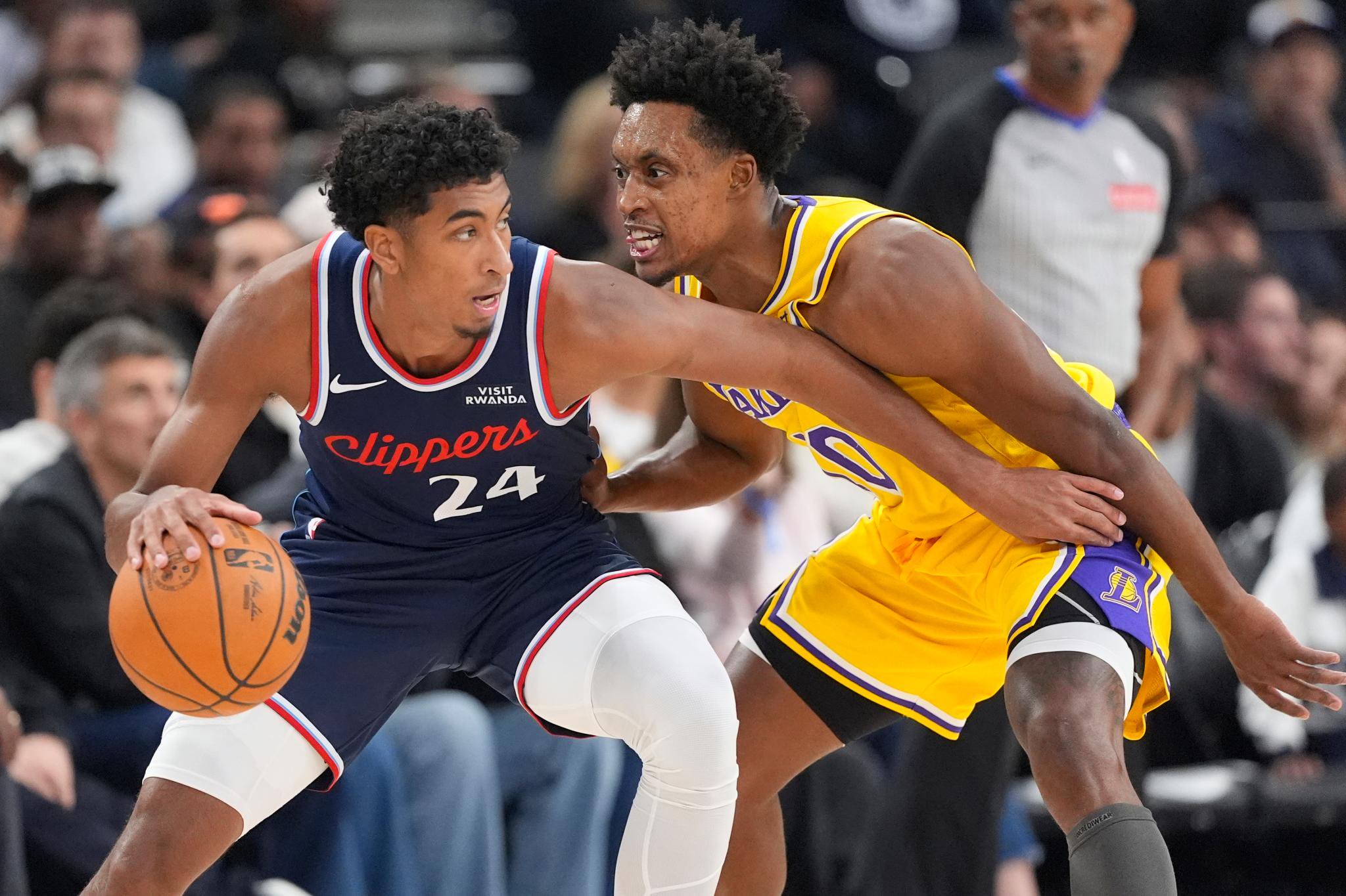 Los Angeles Clippers guard Cam Christie tries to get past Los Angeles Lakers guard Collin Sexton during a game.