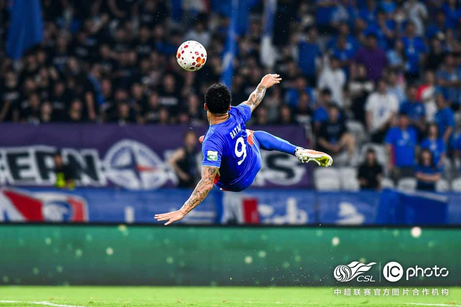 Jogador com camisa azul nº9 faz chute acrobático durante jogo da CSL, em estádio lotado.