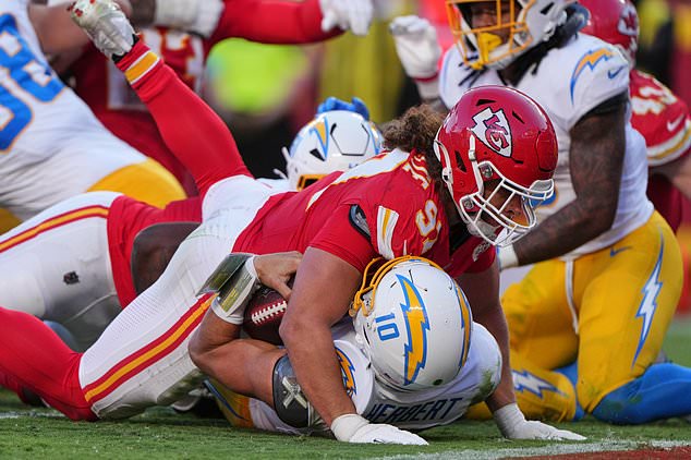 Kansas City Chiefs defensive end Ashton Gillotte (97) lands on top of Los Angeles Chargers quarterback Justin Herbert (10) at the end of a rushing play during the second half of an NFL football game in Kansas City, Mo., Sunday, Oct. 18, 2026. (AP Photo/Charlie Riedel)