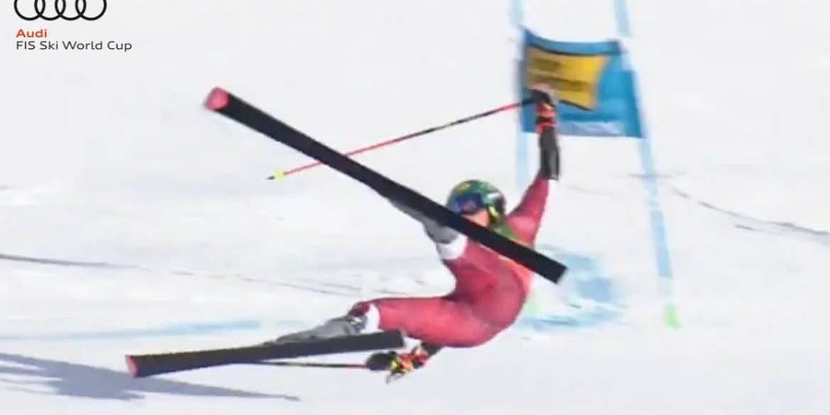 Ein Skifahrer stürzt beim FIS Ski World Cup vor einem blauen Tor auf der Piste.