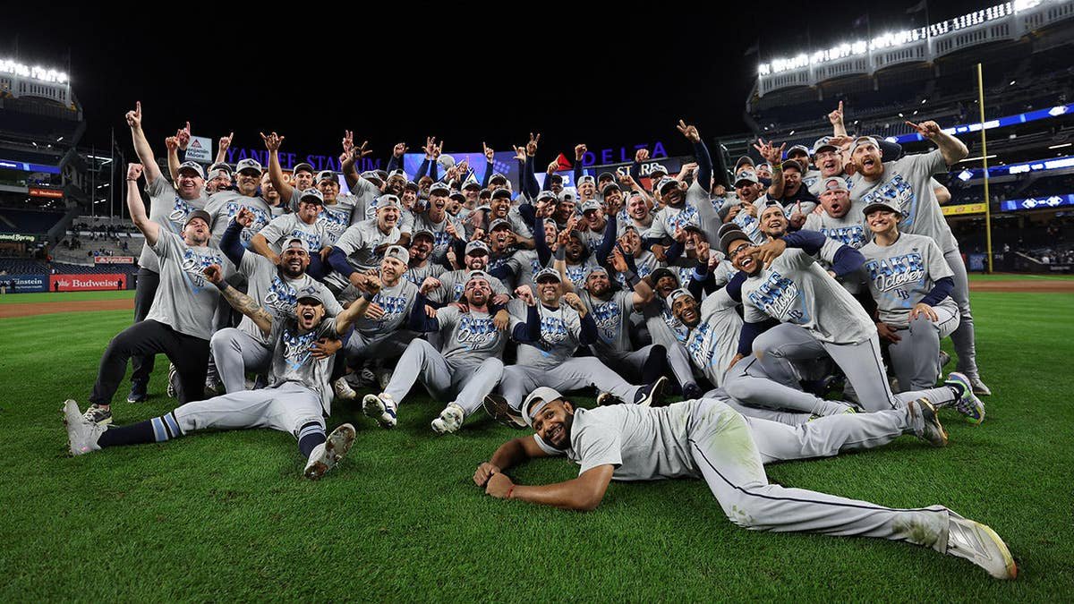 Tampa Bay Rays players pose for a photo at Yankee Stadium after winning Game 3 of the ALDS.