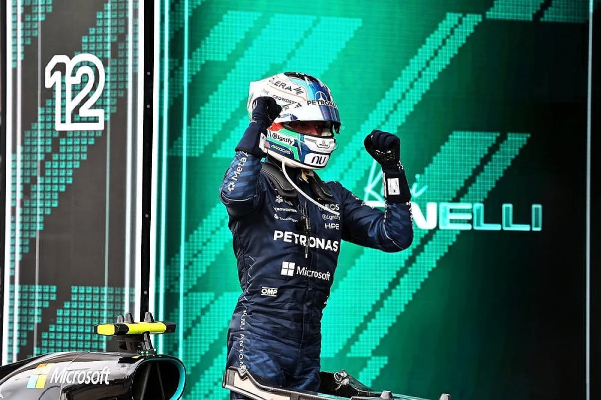 Andrea Kimi Antonelli celebrating on the podium in Mercedes Petronas race suit and helmet, fists raised, Formula 1 Austin win