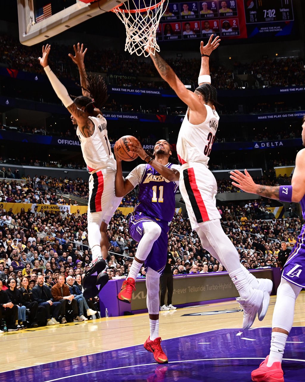 Ziaire Williams of the Los Angeles Lakers drives to the basket against Portland Trail Blazers defenders.