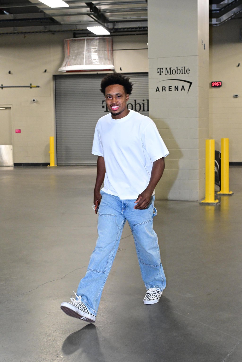 Collin Sexton arrives at the arena wearing a white t-shirt and blue jeans.