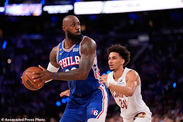 Philadelphia 76ers' LeBron James, left, tries to get past Cleveland Cavaliers' Tyrese Proctor during the first half of an NBA basketball game Thursday, Oct. 22, 2026, in Philadelphia. (AP Photo/Matt Slocum)