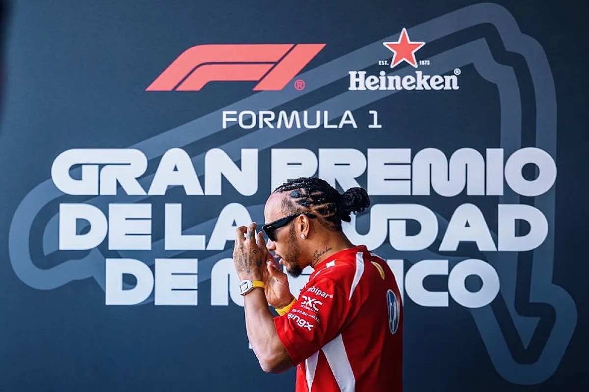 Driver in red Ferrari-style race shirt and sunglasses, hands raised, at the Formula 1 Gran Premio de la Ciudad de México event with Heineken branding