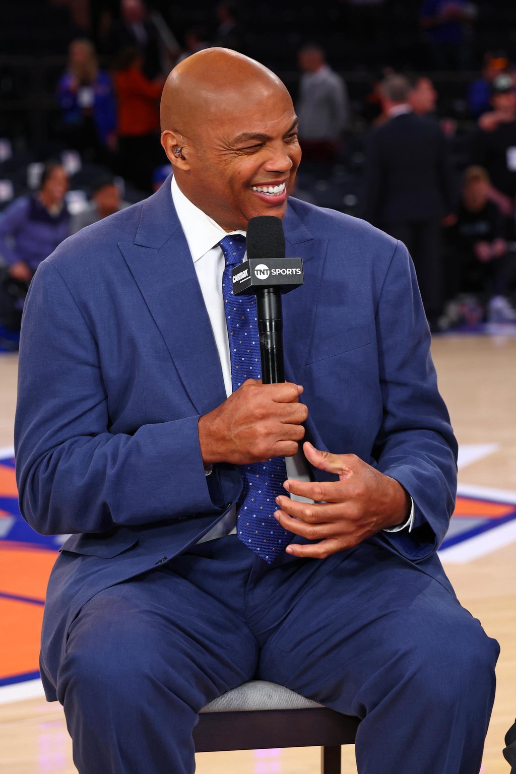 Charles Barkley smiling and holding a microphone during an interview.