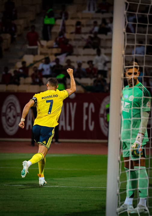 Cristiano Ronaldo, do Al Nassr, celebra gol com o punho erguido diante do goleiro adversário.