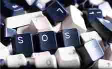 SOS IT HELP - Close up on Three SOS keyboard keys in a Pile of Black and White Computer Keyboard Keys. Three visible keys have letters SOS.